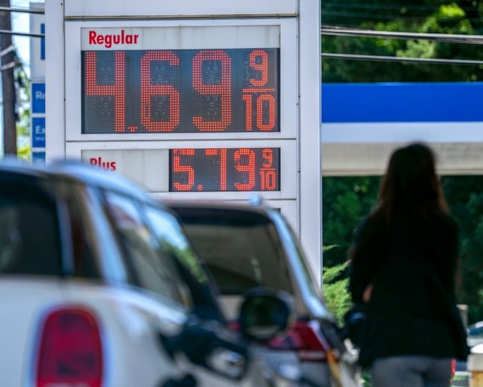 A single bull-horned oil barrel surfing a green flame wave, dollar sign on its side.