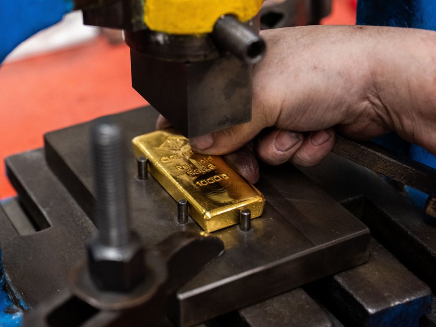 A single gold bar melting like a candle on a hot stovetop.