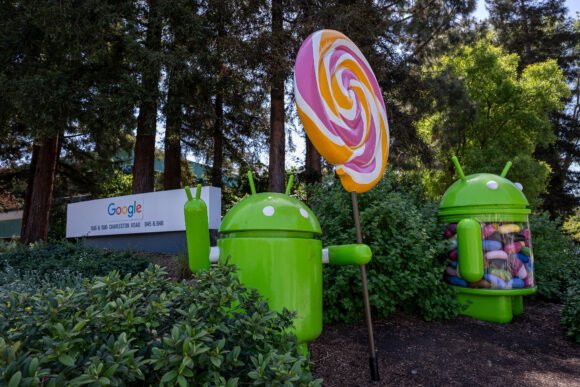 A single green Android robot mascot slumped on a courthouse bench, holding a giant deflated pink slip.