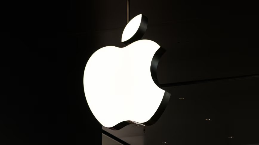 A single lone iPhone lying face-up on a courtroom table, vibrating so hard it's bouncing off the wood like a jackhammer.